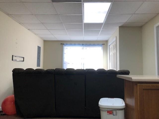 living room featuring a paneled ceiling and electric panel