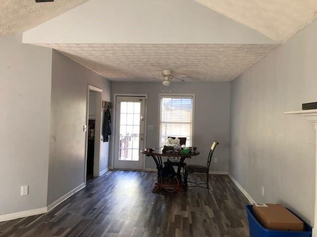 dining space featuring ceiling fan, dark hardwood / wood-style floors, lofted ceiling, and a textured ceiling