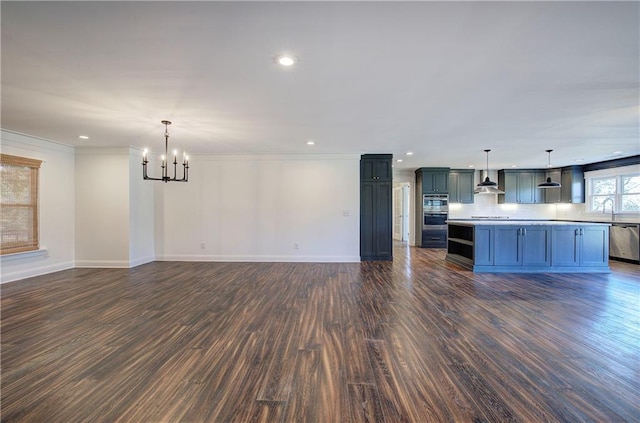 unfurnished living room featuring dark hardwood / wood-style flooring, a notable chandelier, and ornamental molding