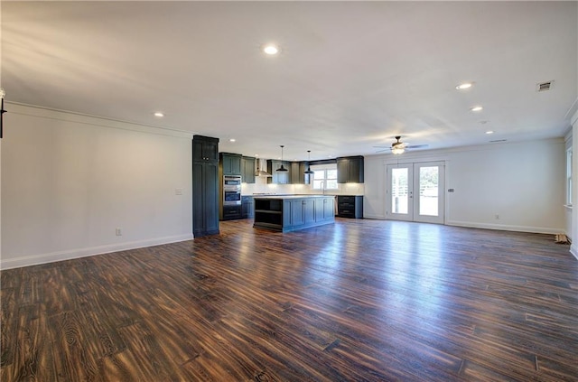 unfurnished living room featuring french doors, crown molding, dark wood-type flooring, and sink