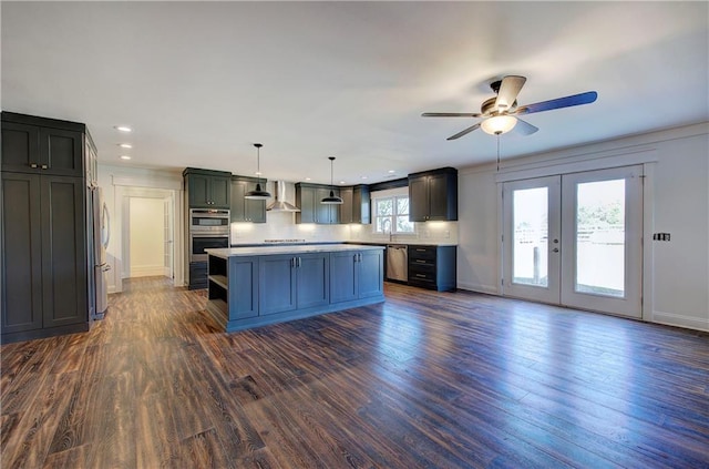 kitchen with a wealth of natural light, a center island, pendant lighting, and wall chimney range hood