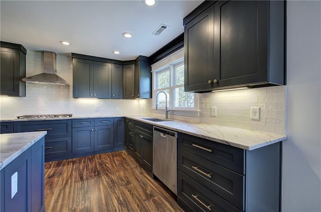 kitchen with backsplash, dark wood-type flooring, sink, wall chimney exhaust hood, and appliances with stainless steel finishes