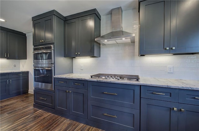 kitchen featuring wall chimney exhaust hood, dark hardwood / wood-style floors, decorative backsplash, and appliances with stainless steel finishes