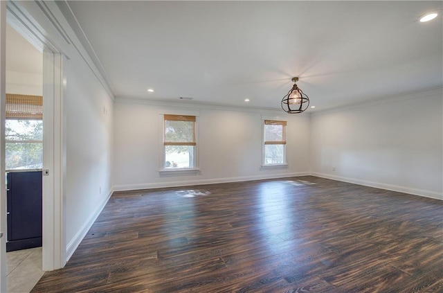 unfurnished room featuring a chandelier, dark hardwood / wood-style floors, and ornamental molding