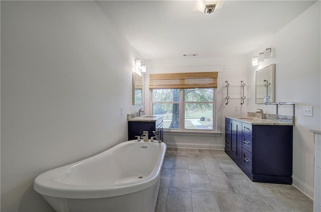 bathroom featuring a bathing tub, tile patterned flooring, and vanity