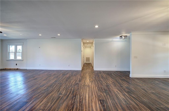 empty room with dark hardwood / wood-style flooring and crown molding