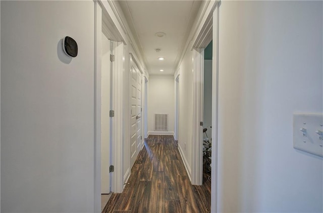 hallway with dark hardwood / wood-style floors and crown molding