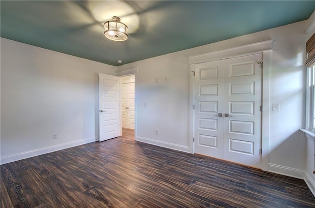 unfurnished bedroom featuring a closet and dark hardwood / wood-style floors