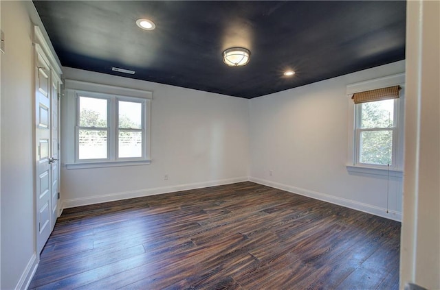 unfurnished room featuring plenty of natural light and dark hardwood / wood-style floors