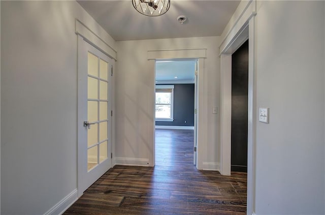 corridor featuring dark hardwood / wood-style flooring, french doors, and a notable chandelier