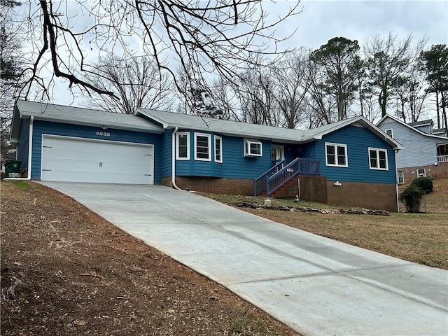 single story home with a garage and a wall unit AC