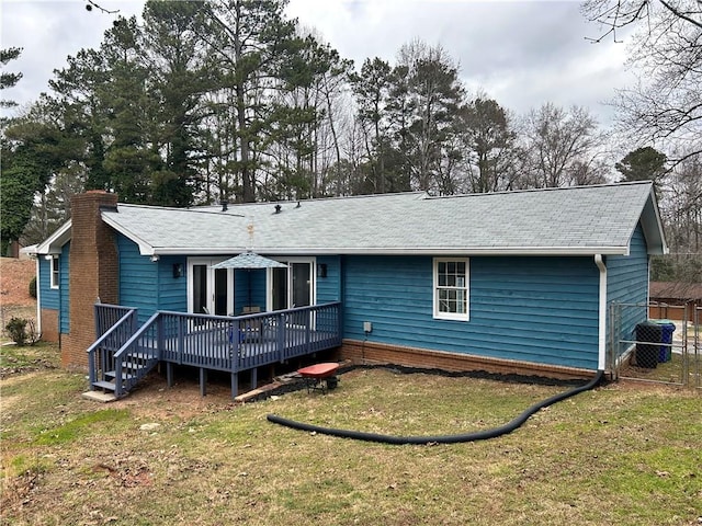 rear view of property with cooling unit, a deck, and a lawn