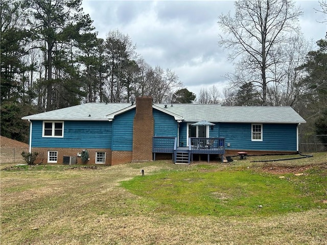 back of property with central AC unit, a lawn, and a deck