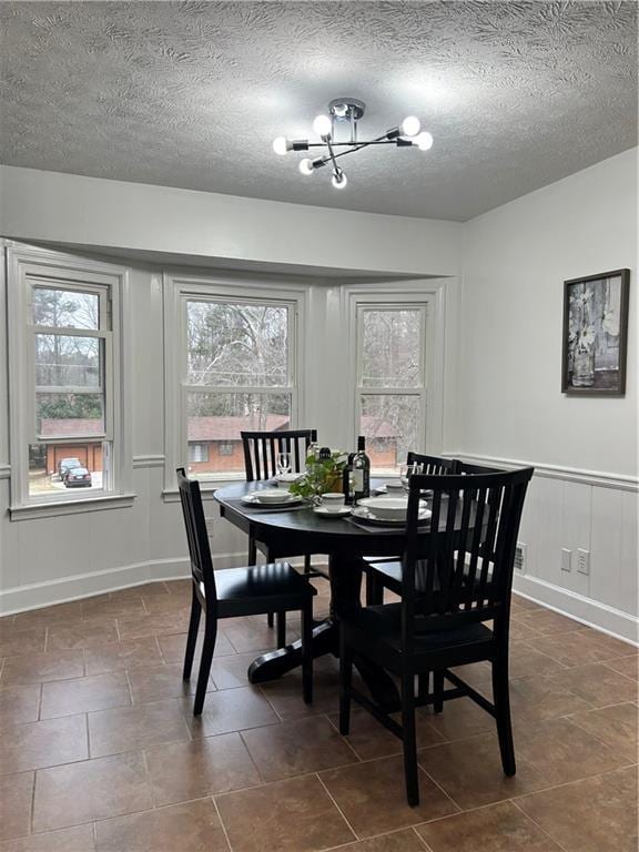 dining area with a textured ceiling and a chandelier