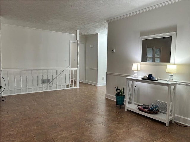 spare room with ornamental molding and a textured ceiling