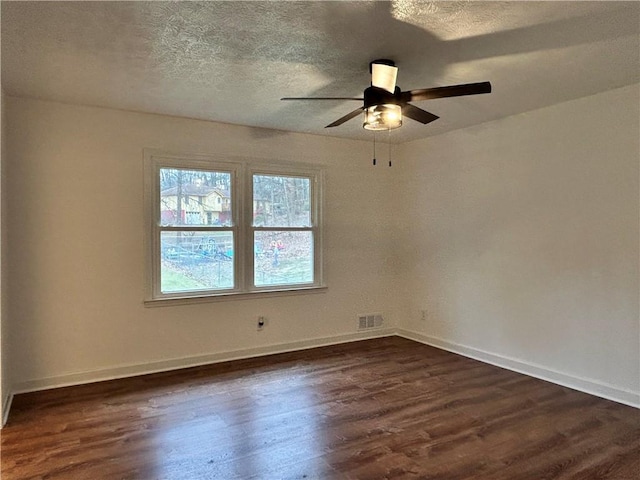 empty room with ceiling fan, dark hardwood / wood-style floors, and a textured ceiling