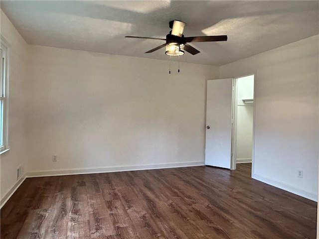 empty room featuring ceiling fan and dark hardwood / wood-style flooring