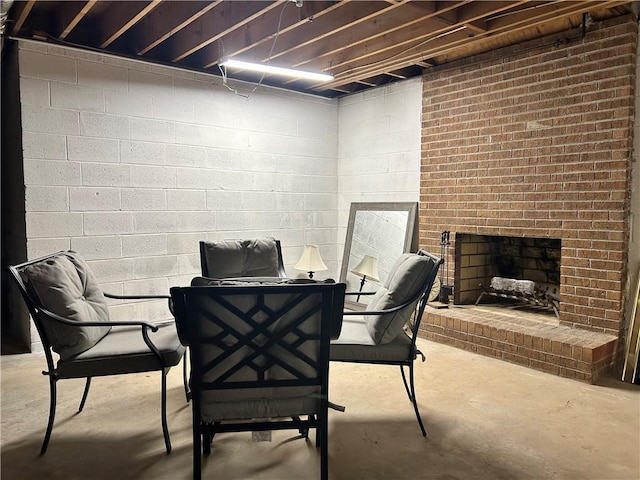 dining room featuring a fireplace and concrete flooring