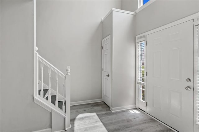 entrance foyer featuring wood finished floors, baseboards, stairs, and a high ceiling