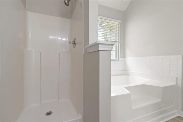 full bath with a stall shower and a garden tub