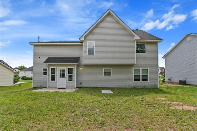 back of house featuring central AC unit, a patio area, and a yard
