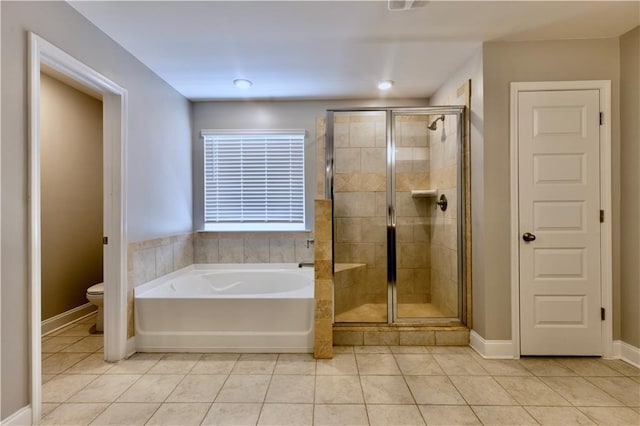 133 Canal St, Hampton, GA 30228 - bathroom with tile patterned floors, a shower stall, a bath, toilet, and baseboards