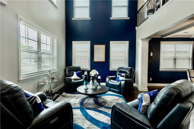 133 Canal St, Hampton, GA 30228 - living area featuring wood finished floors, decorative columns, a high ceiling, and baseboards