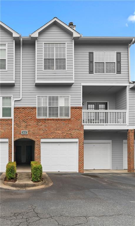 108 Vinings Forest Cir SE, Smyrna, GA 30080 - townhome / multi-family property featuring a garage, driveway, and brick siding