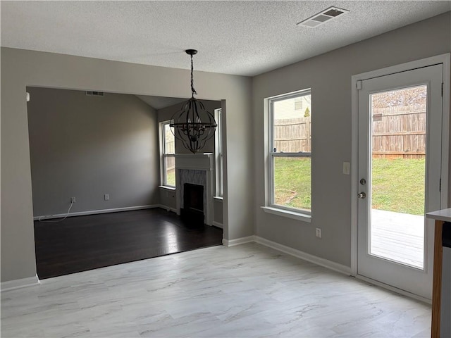 unfurnished dining area featuring a chandelier and a textured ceiling