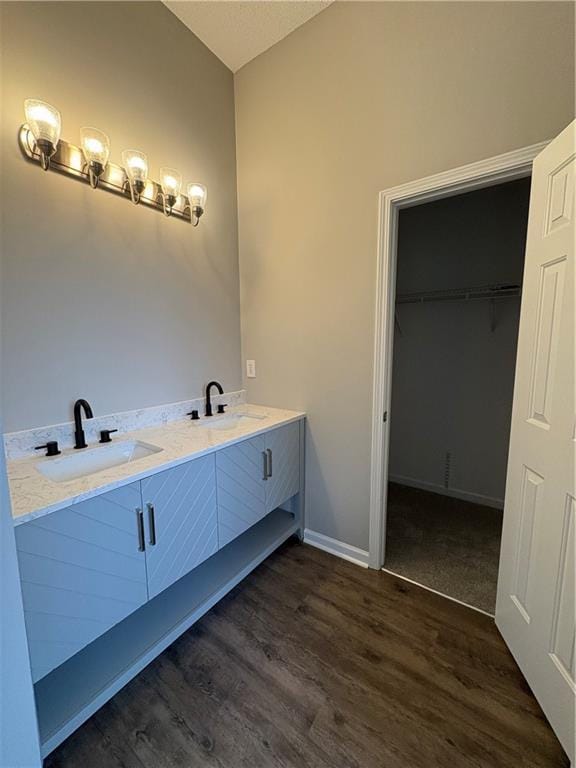 bathroom featuring vanity, hardwood / wood-style flooring, and vaulted ceiling