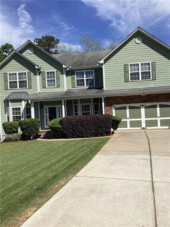 view of front facade with an attached garage, driveway, and a front lawn