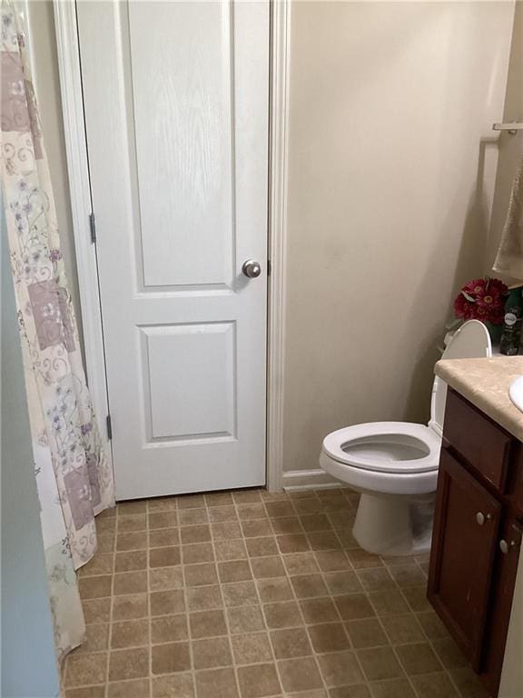 full bath featuring vanity, baseboards, and toilet