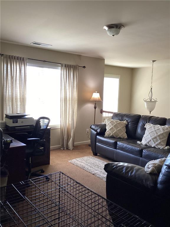 carpeted living room with baseboards and visible vents