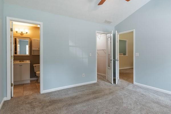 4841 Partee Trl, Social Circle, GA 30025 - unfurnished bedroom featuring carpet flooring, a spacious closet, connected bathroom, baseboards, and vaulted ceiling
