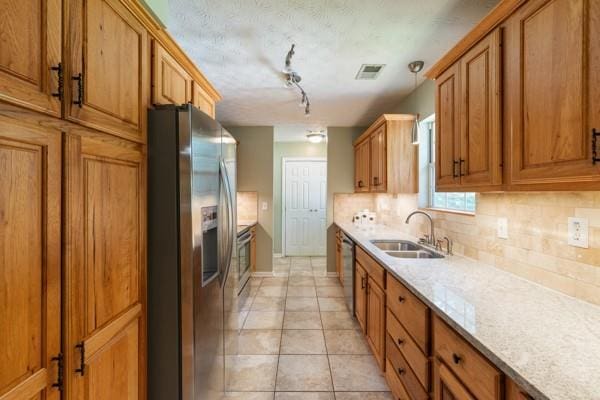 4841 Partee Trl, Social Circle, GA 30025 - kitchen with appliances with stainless steel finishes, decorative backsplash, and brown cabinetry