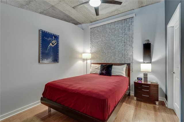 bedroom with ceiling fan, baseboards, and wood finished floors