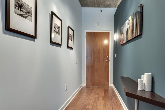 doorway to outside featuring light wood finished floors, visible vents, and baseboards