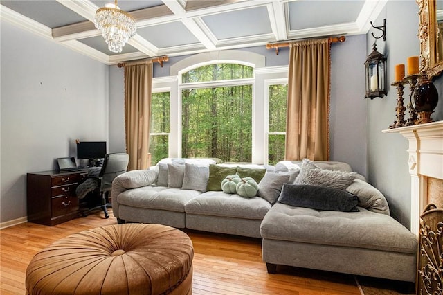 living area featuring light wood-style floors, an inviting chandelier, beamed ceiling, ornamental molding, and coffered ceiling
