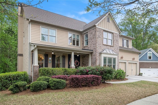 craftsman inspired home featuring a garage, brick siding, driveway, and board and batten siding