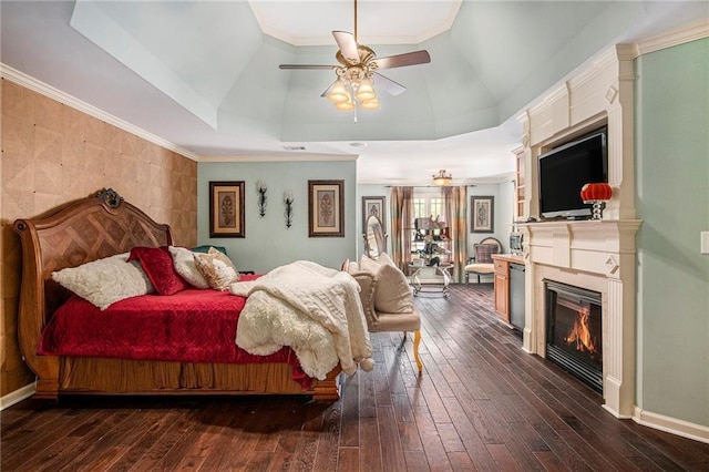 bedroom featuring baseboards, a ceiling fan, vaulted ceiling, dark wood-type flooring, and a glass covered fireplace
