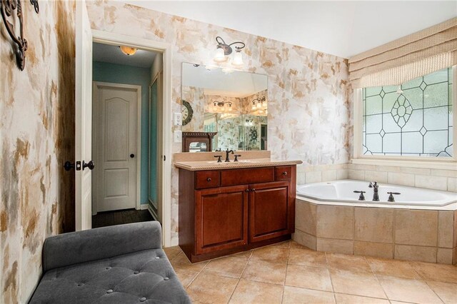 bathroom featuring tile patterned flooring, vanity, a bath, and wallpapered walls