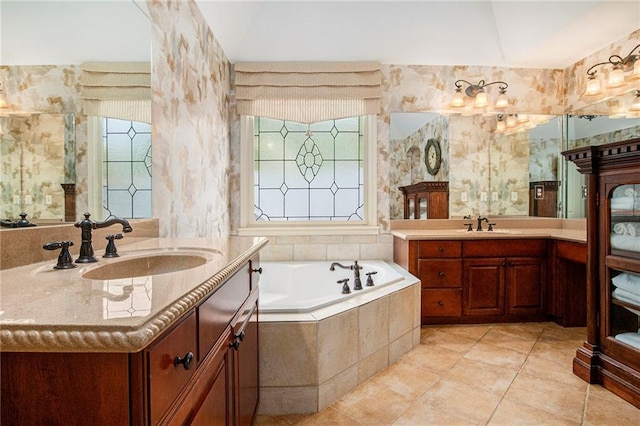 bathroom featuring plenty of natural light, a garden tub, a sink, and tile patterned flooring