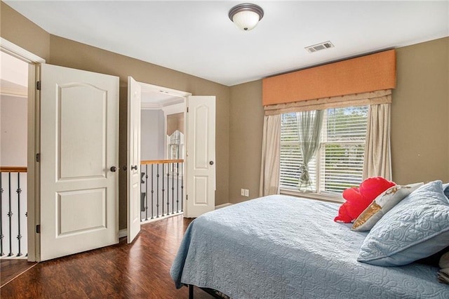 bedroom featuring visible vents and wood finished floors