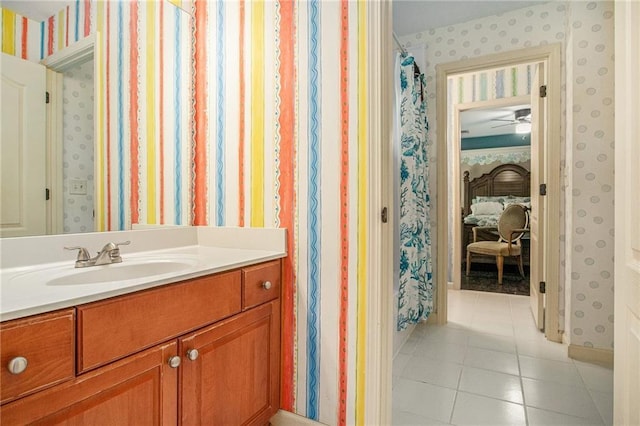 ensuite bathroom featuring vanity, wallpapered walls, tile patterned floors, ensuite bathroom, and ceiling fan