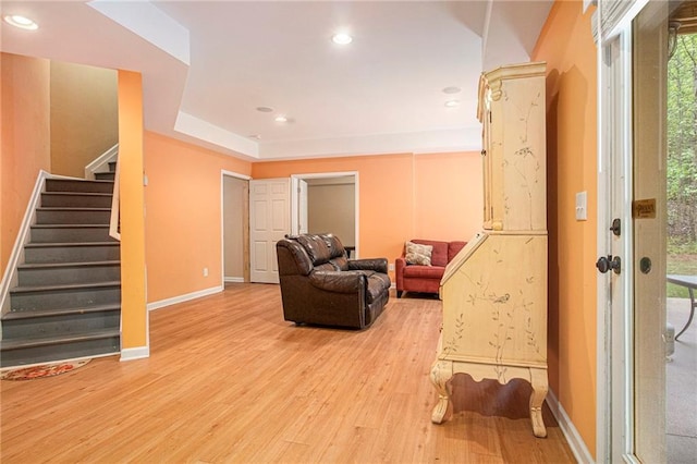sitting room with light wood-style flooring, recessed lighting, baseboards, and stairs
