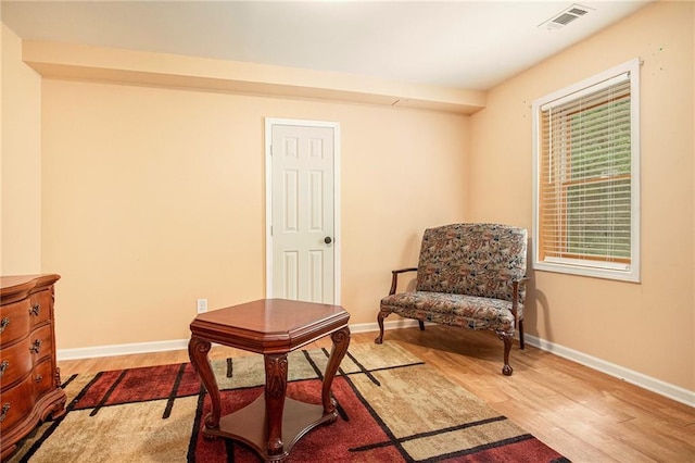 living area featuring visible vents, baseboards, and light wood-style floors