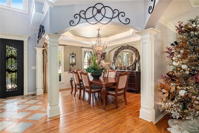 dining room with a wealth of natural light, ornate columns, arched walkways, and an inviting chandelier