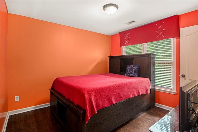 bedroom with wood finished floors, baseboards, and visible vents