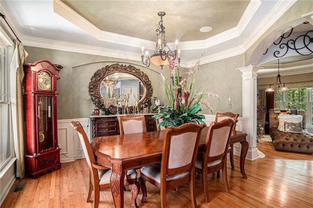dining space with visible vents, a notable chandelier, decorative columns, crown molding, and light wood-style flooring