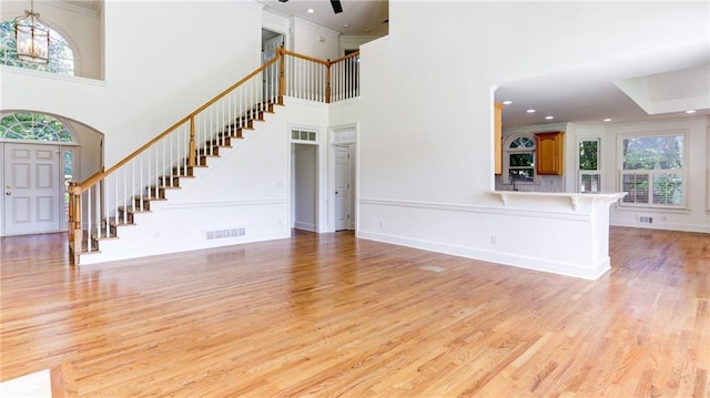 127 Grandmar Chase, Canton, GA 30115 - unfurnished living room with stairway, light wood-style flooring, crown molding, a high ceiling, and recessed lighting